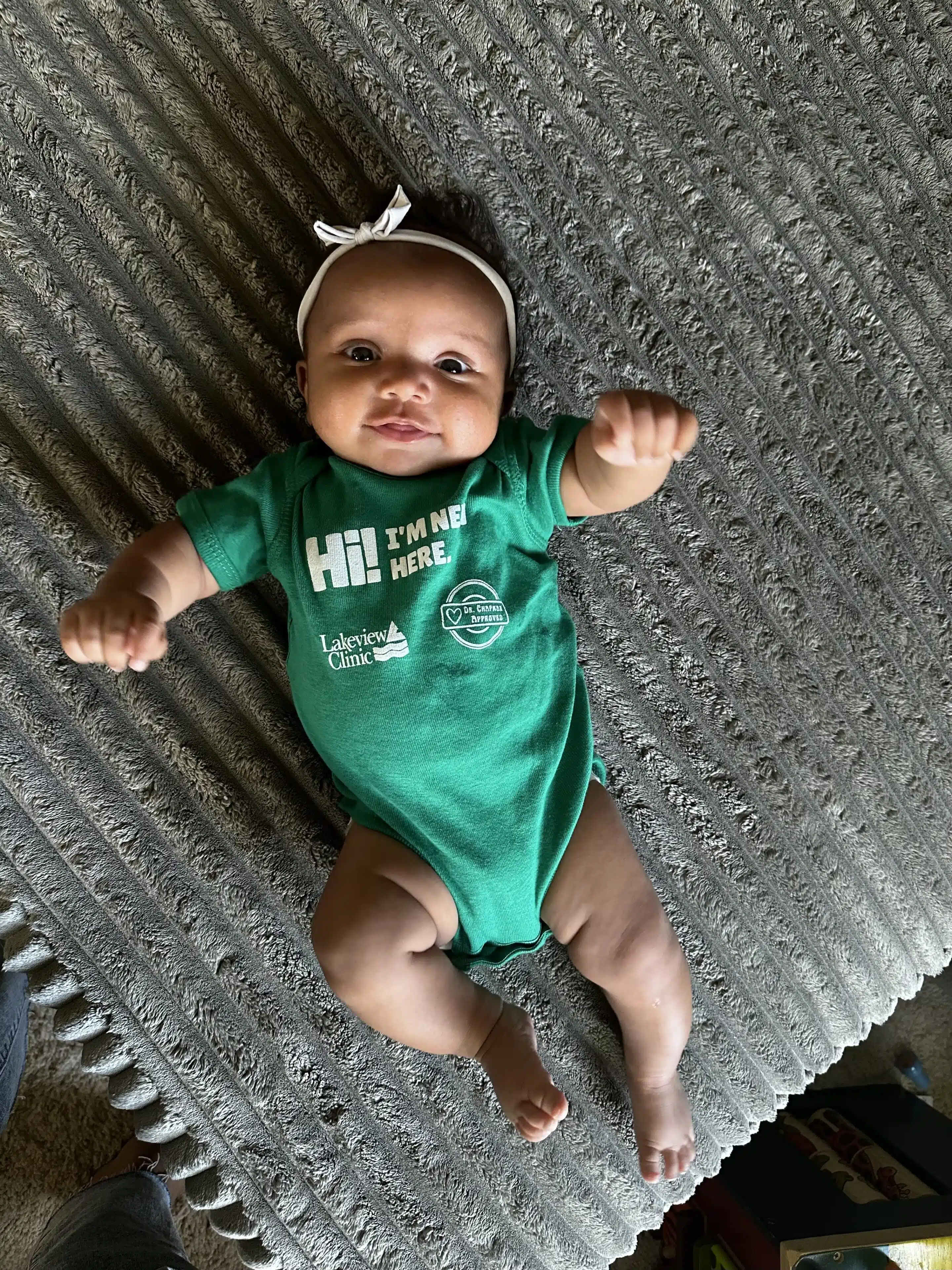 NB.Ezi.828 Green Lakeview onesie on blue background.